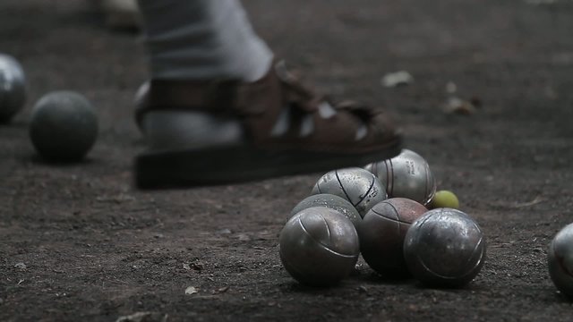 elderly people enjoying to play boules in a park, ball shooting
