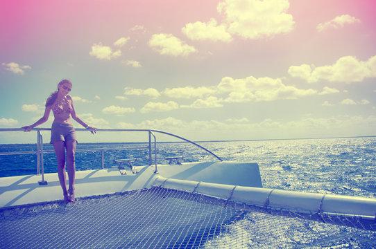 A woman holding a rail on a catamaran in the Caribbean Sea