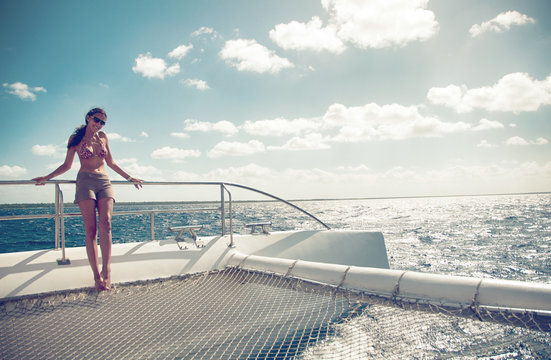 A woman holding a rail on a catamaran in the Caribbean Sea