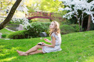 Obraz premium Young European woman eating sushi in Japanese park