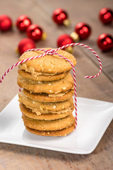 Stack of cookies on white plate with red balls