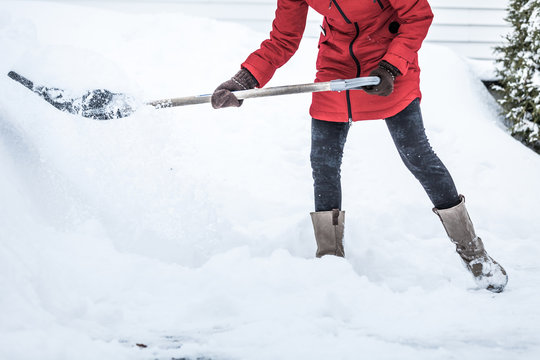 Close-up of Woman Shoveling her Parking lot
