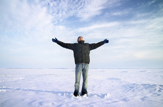 Persons on ice. Man with arms raised