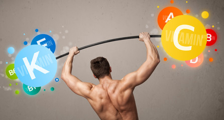 muscular man lifting colorful vitamin weights