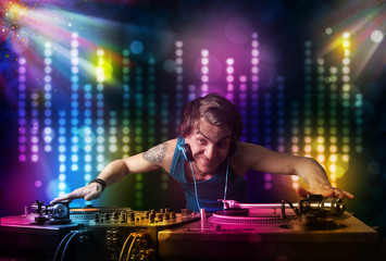 Obraz na płótnie Canvas Dj playing songs in a disco with light show