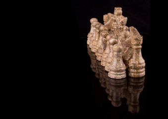 Fototapeta premium Stone made chess set on black background
