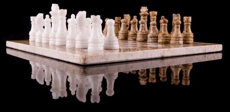 Stone made chess set on black background