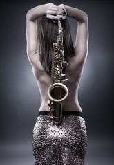 Obraz premium Young woman with saxophone