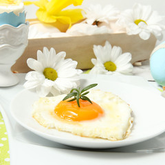 Easter table setting with flowers and eggs on old wooden table