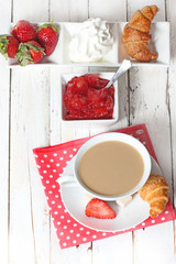 breakfast with croissants, strawberry  and cup of coffe on white