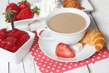 breakfast with croissants, strawberry  and cup of coffe on white