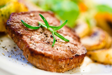 Grilled steak, baked potatoes and vegetables