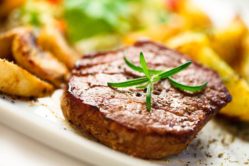 Grilled steak, baked potatoes and vegetables
