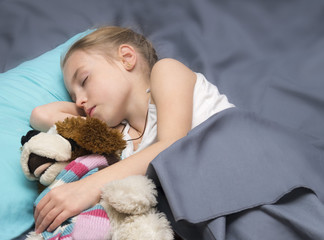 child sleeping with her a favorite toy