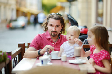 Father and his daughters relaxing in outdoor cafe