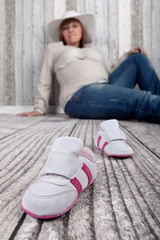 Babyschuhe und schwangere Frau