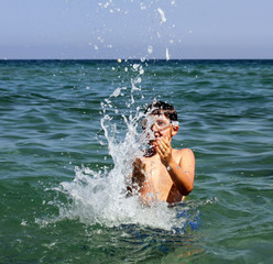 Active boy playing with sea water.
