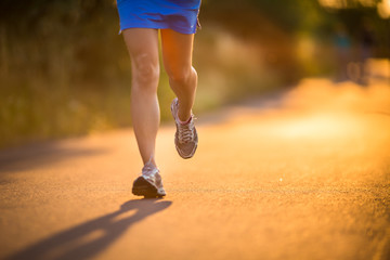 Young woman running outdoors on a lovely sunny summer evening