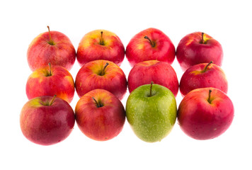 Green apple among red apples on white background.