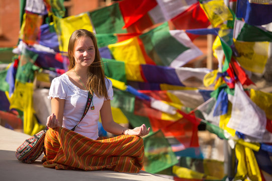 Girl sitting in the Lotus position on Buddhist stupa.
