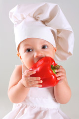 Little baby in a cap chef with Pepper