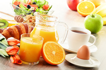 Breakfast with coffee, juice, croissant, salad, muesli and egg