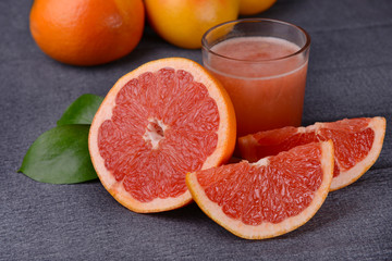 Ripe grapefruit with juice on table close-up