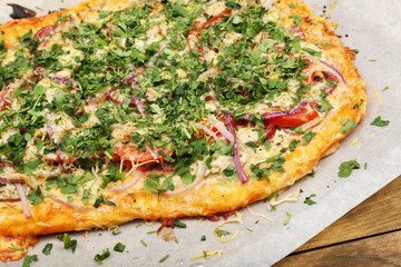 Homemade pizza on baking paper close up