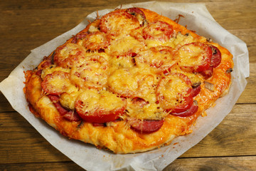 Homemade pizza on baking paper close up