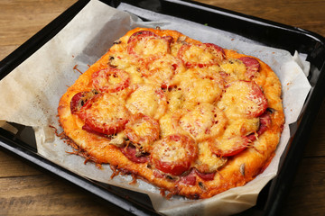 Homemade pizza on baking paper close up