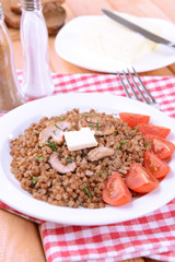 Boiled buckwheat on plate on table close-up