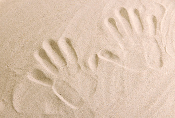 Hand prints in sand as nice summer background