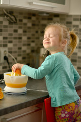 little girl squeezing orange juice