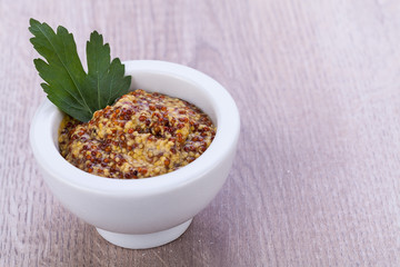 fresh yellow mustard in white bowl with parsley decorated