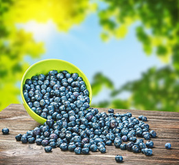 Blueberries в тарелке is scattered on the wooden table