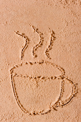 drawing in the sand a hot cup of coffee
