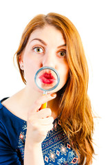 cheerful girl fooling around with a magnifying loupe