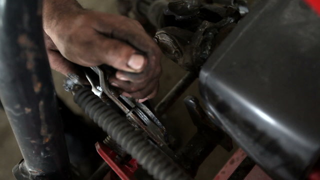 Closeup of mechanic with dirty hands fixing with wrench