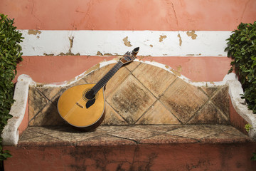 traditional portuguese guitar on a stone bench.