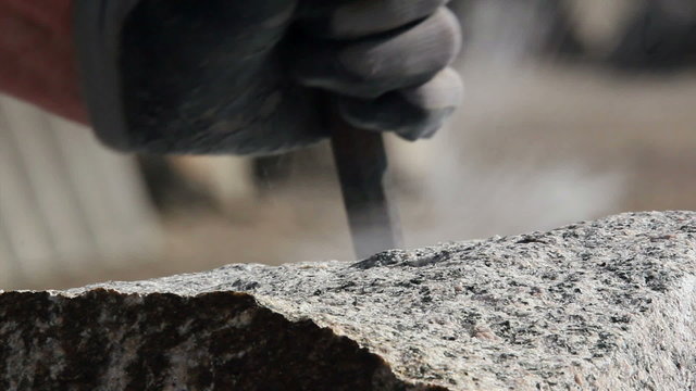 Stonemason making wedge-holes manually