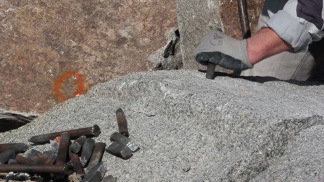 Stonemason making wedge-holes manually
