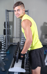 Obraz na płótnie Canvas Guy with dumbbells in gym