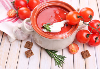 Tasty tomato soup and vegetables on wooden table