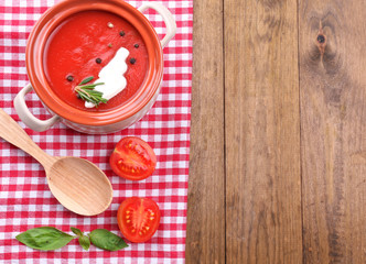 Tasty tomato soup on wooden table