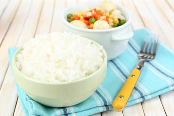 Cooked rice with vegetables on wooden table close up