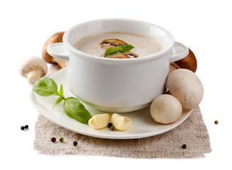 Mushroom soup in white bowl, on napkin, isolated on white