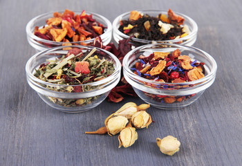 Aromatic dry tea in bowls on wooden background