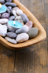 Fototapeta na wymiar Wooden bowl with Spa stones, sea shells and candles