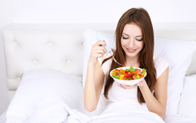 Young beautiful woman in bed with light breakfast