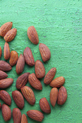 Almonds on color wooden background
